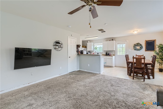 unfurnished living room with ceiling fan and light carpet