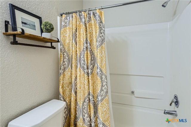 bathroom featuring toilet and shower / tub combo with curtain