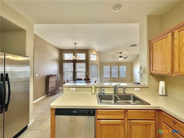 kitchen featuring appliances with stainless steel finishes, light tile patterned floors, sink, kitchen peninsula, and ceiling fan with notable chandelier