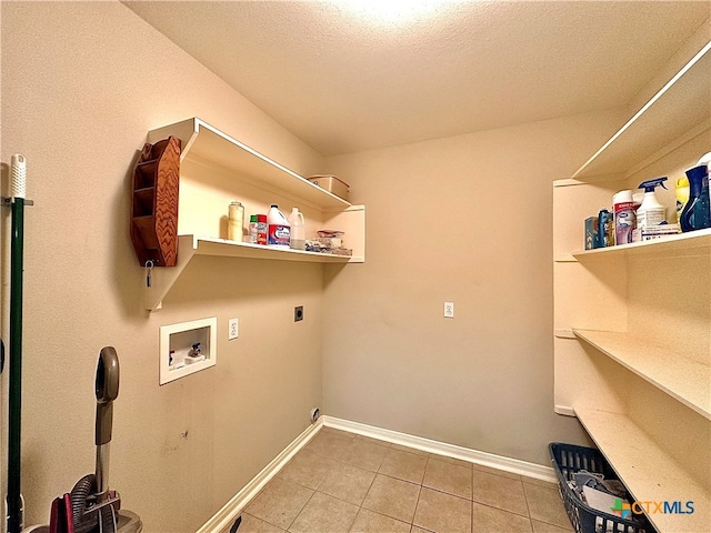 washroom with hookup for a washing machine, electric dryer hookup, a textured ceiling, and tile patterned floors