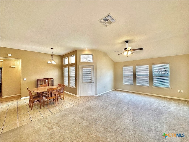 carpeted dining space with lofted ceiling, a textured ceiling, and ceiling fan with notable chandelier