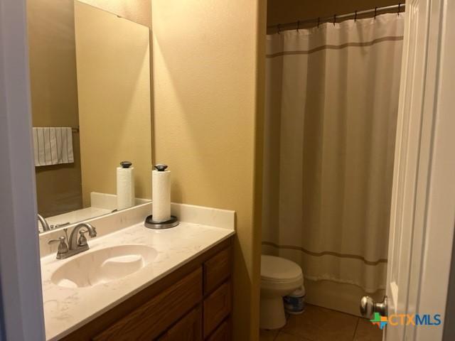 2107 Golden Eagle Dr, Killeen, TX 76549 - full bathroom featuring vanity, a shower with shower curtain, tile patterned flooring, and toilet