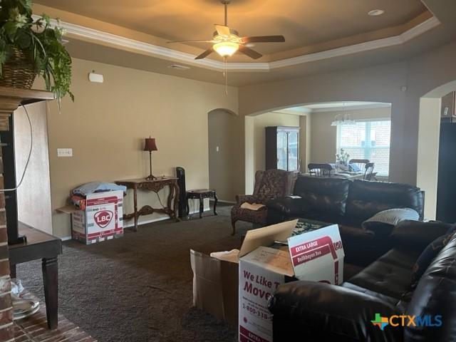 2107 Golden Eagle Dr, Killeen, TX 76549 - living room featuring ceiling fan, a tray ceiling, arched walkways, and carpet flooring