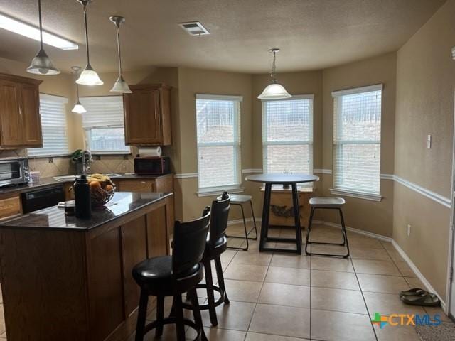 2107 Golden Eagle Dr, Killeen, TX 76549 - kitchen with dark countertops, a healthy amount of sunlight, visible vents, and light tile patterned flooring