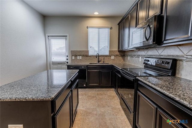 kitchen with black appliances, dark stone counters, sink, a kitchen island, and backsplash