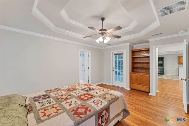 bedroom featuring access to exterior, ornamental molding, a tray ceiling, ceiling fan, and hardwood / wood-style floors