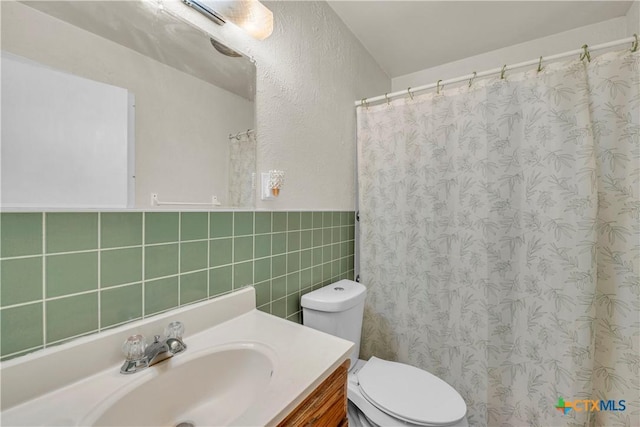 1210 Ridgemont Dr, Killeen, TX 76549 - full bathroom with tile walls, toilet, vanity, curtained shower, and a wainscoted wall