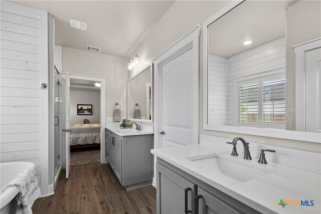 117 Aidan Ct, Burnet, TX 78611 - ensuite bathroom featuring vanity, wood finished floors, a bath, and a shower with shower door