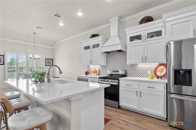 117 Aidan Ct, Burnet, TX 78611 - kitchen featuring appliances with stainless steel finishes, custom range hood, a sink, crown molding, and a chandelier