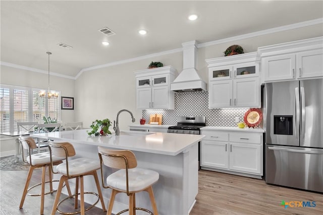 117 Aidan Ct, Burnet, TX 78611 - kitchen featuring appliances with stainless steel finishes, a sink, custom range hood, light wood-type flooring, and light countertops