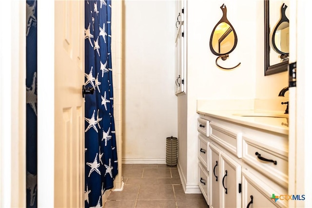 bathroom with a shower with shower curtain, tile patterned flooring, baseboards, and vanity