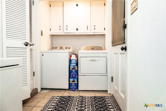 clothes washing area featuring cabinet space, light tile patterned flooring, and independent washer and dryer