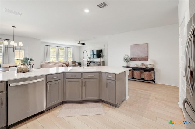 4648 Padula Dr, Round Rock, TX 78665 - kitchen featuring appliances with stainless steel finishes, gray cabinetry, open floor plan, a chandelier, and light countertops