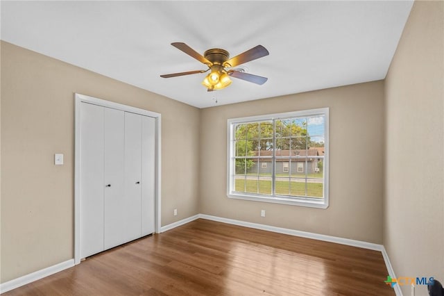 454 W Ward St, Goliad, TX 77963 - unfurnished bedroom with wood finished floors, a closet, and a ceiling fan