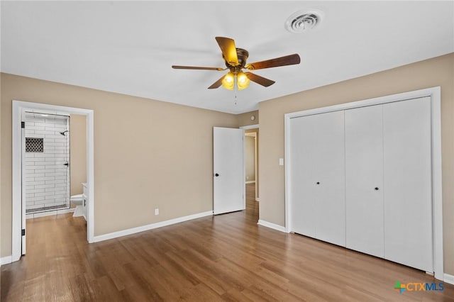 454 W Ward St, Goliad, TX 77963 - unfurnished bedroom with wood finished floors, a closet, a ceiling fan, and ensuite bath