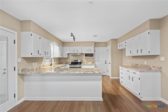 454 W Ward St, Goliad, TX 77963 - kitchen featuring stainless steel electric range, dark wood-type flooring, a peninsula, and light stone countertops