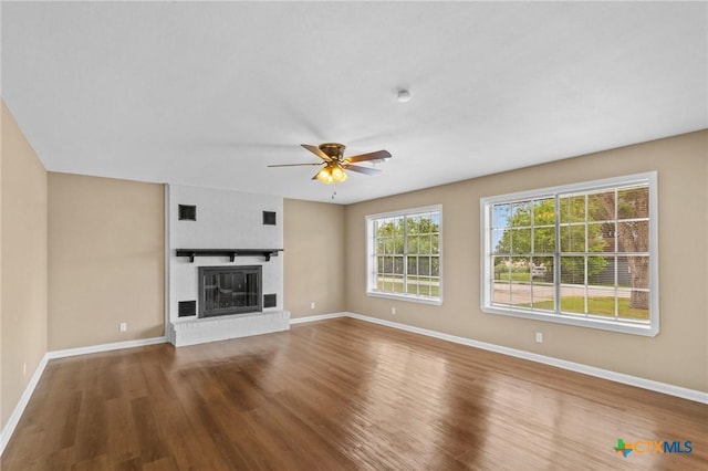 454 W Ward St, Goliad, TX 77963 - unfurnished living room featuring wood finished floors, ceiling fan, and a fireplace