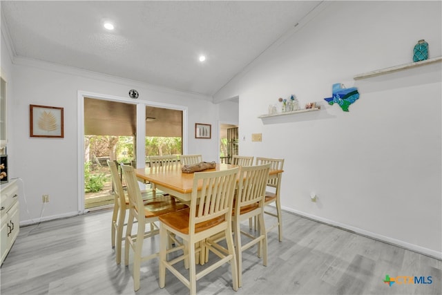 dining room with light wood-type flooring, lofted ceiling, a textured ceiling, and crown molding