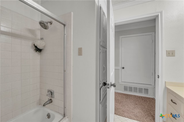 bathroom featuring ornamental molding, vanity, and tiled shower / bath