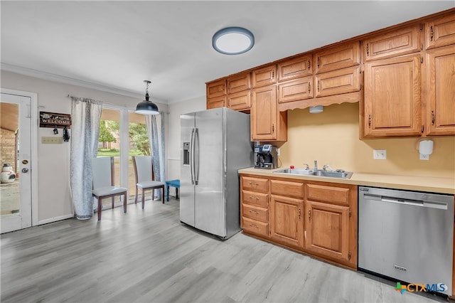 kitchen featuring pendant lighting, light hardwood / wood-style floors, appliances with stainless steel finishes, and sink