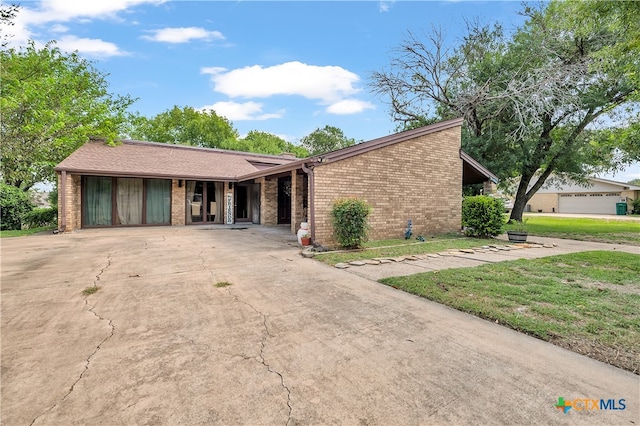 ranch-style home featuring a garage and a front lawn