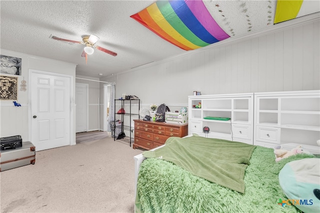 carpeted bedroom featuring ceiling fan, a textured ceiling, and ornamental molding