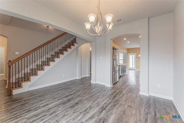 1233 Jester Ct, Copperas Cove, TX 76522 - unfurnished living room with visible vents, an inviting chandelier, dark wood-style flooring, stairs, and arched walkways