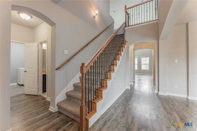 1233 Jester Ct, Copperas Cove, TX 76522 - stairway with baseboards, arched walkways, a towering ceiling, and wood finished floors