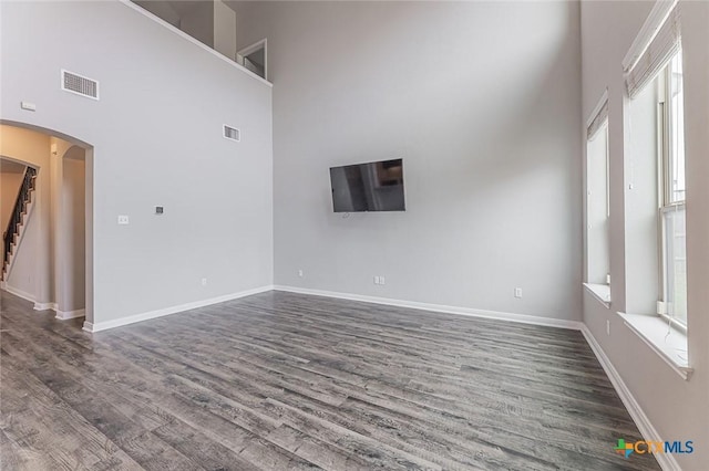 1233 Jester Ct, Copperas Cove, TX 76522 - empty room featuring arched walkways, a high ceiling, visible vents, and a healthy amount of sunlight