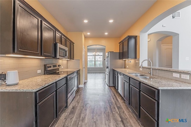 1233 Jester Ct, Copperas Cove, TX 76522 - kitchen with dark brown cabinets, a sink, stainless steel appliances, wood finished floors, and backsplash