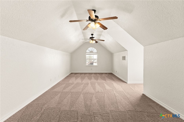 bonus room with a ceiling fan, a textured ceiling, lofted ceiling, light colored carpet, and a textured wall