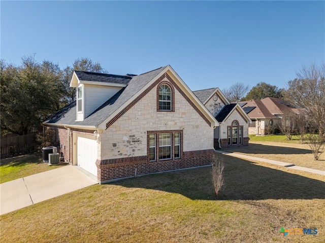 view of front of home with a front lawn, driveway, stone siding, an attached garage, and a shingled roof