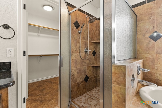 full bath featuring a shower stall and a spacious closet