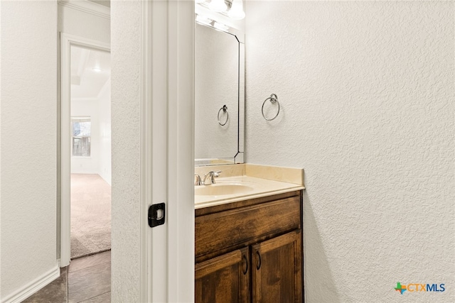 bathroom with vanity and a textured wall