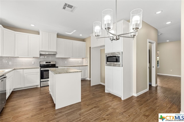 kitchen featuring appliances with stainless steel finishes, light stone counters, a center island, white cabinetry, and hanging light fixtures