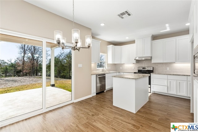 kitchen featuring white cabinets, hanging light fixtures, a notable chandelier, a kitchen island, and stainless steel appliances