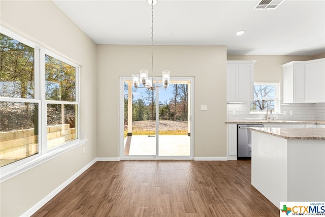 kitchen featuring dishwasher, white cabinets, hanging light fixtures, decorative backsplash, and dark hardwood / wood-style flooring