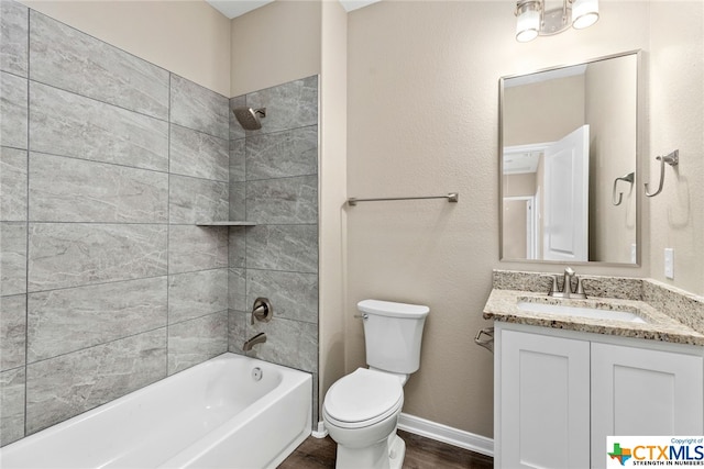 full bathroom featuring hardwood / wood-style floors, vanity, toilet, and tiled shower / bath