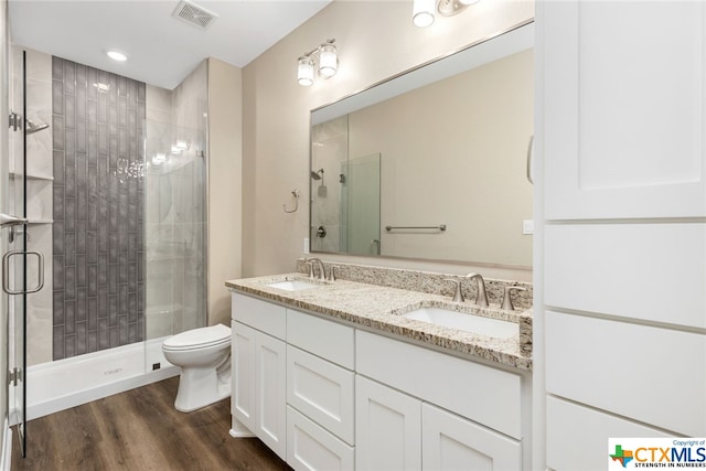 bathroom featuring vanity, hardwood / wood-style flooring, toilet, and an enclosed shower