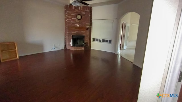 unfurnished living room with ceiling fan and a brick fireplace