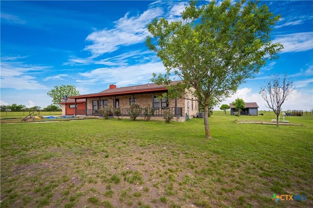 back of house with a lawn, brick siding, and a pool