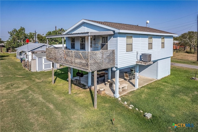 back of house featuring central AC unit, a yard, a storage shed, and a patio area