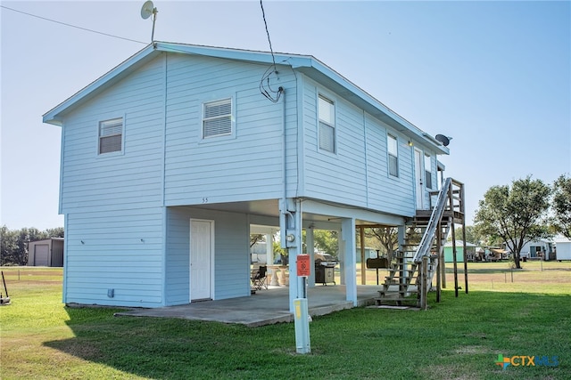 back of property with a lawn and a patio area