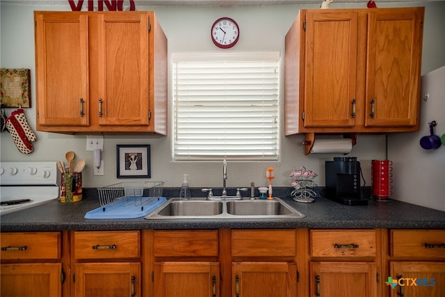 kitchen featuring white range and sink