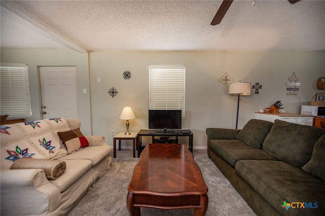 carpeted living room with ceiling fan and a textured ceiling