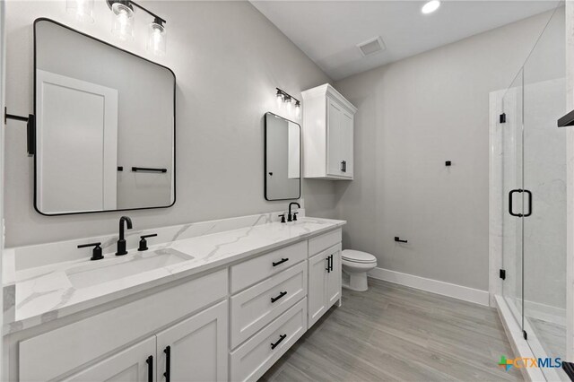 644 Creekside Dr, Belton, TX 76513 - full bathroom featuring double vanity, baseboards, a stall shower, toilet, and wood finished floors