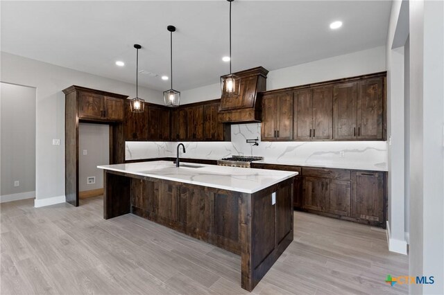 644 Creekside Dr, Belton, TX 76513 - kitchen with custom exhaust hood, light wood-style flooring, dark brown cabinetry, hanging light fixtures, and recessed lighting