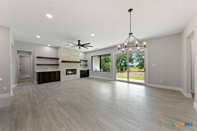 644 Creekside Dr, Belton, TX 76513 - unfurnished living room with baseboards, a chandelier, a ceiling fan, a stone fireplace, and recessed lighting