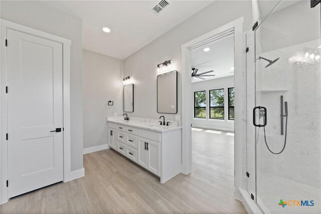 644 Creekside Dr, Belton, TX 76513 - full bathroom with a marble finish shower, double vanity, a ceiling fan, baseboards, and wood finished floors