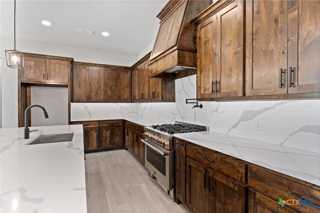 644 Creekside Dr, Belton, TX 76513 - kitchen with high end range, a sink, premium range hood, light stone countertops, and light wood-style floors